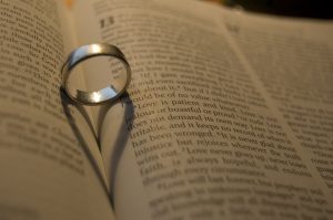 Photography of a ring creating a heart shadow in the crease of a book, talking about what love is.