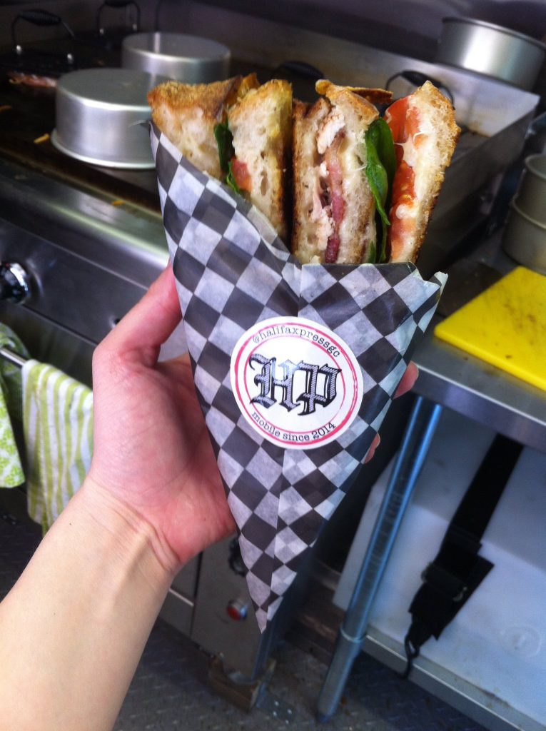 Halifax Press sticker on the checkered wrapper of a freshly grilled cheese sandwich.